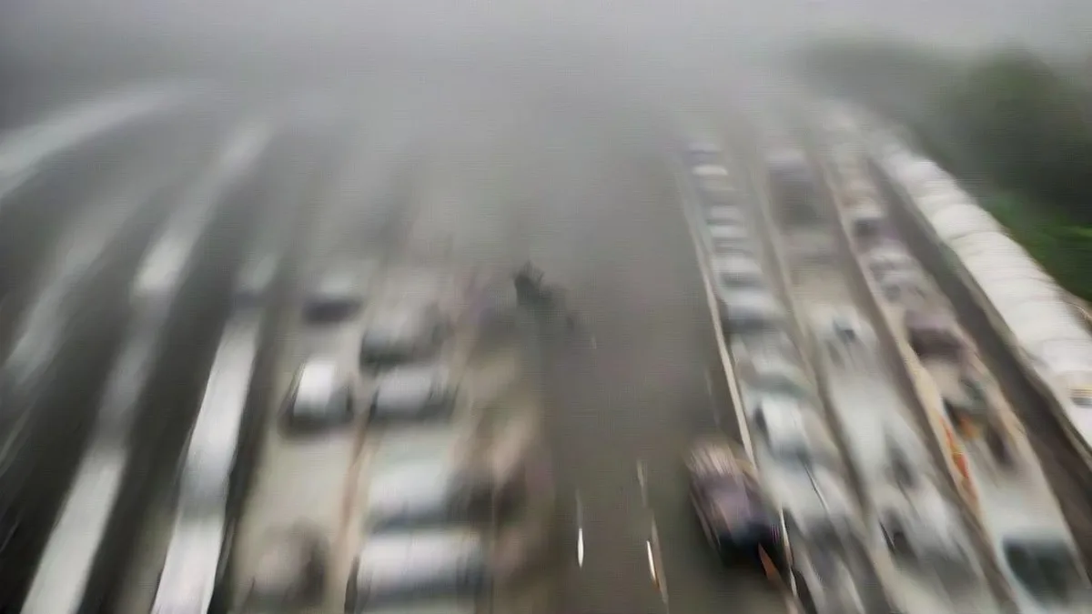 Hazy overcast morning over a busy Delhi highway with traffic.