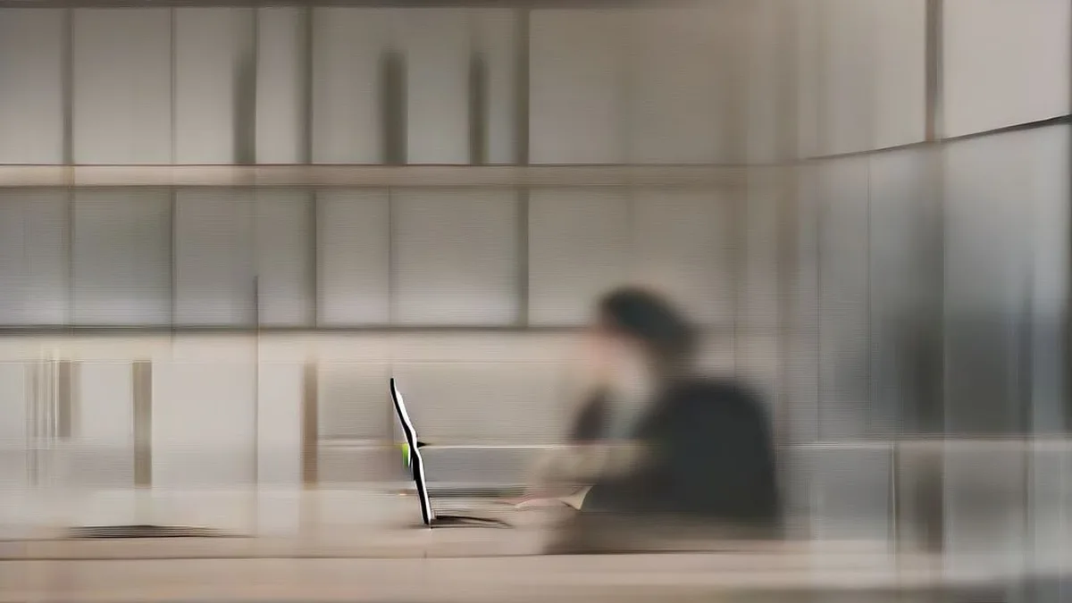 A professional working on a laptop in a modern office environment