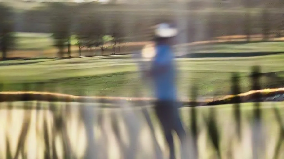 Professional golfer executing a swing on the fairway during a tournament round.