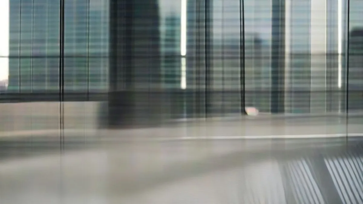 A corporate professional working in a modern high-rise office reflecting market challenges.