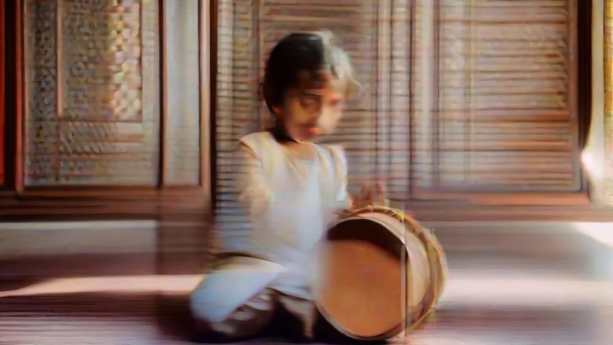 A toddler practicing on a pair of traditional Indian tabla drums.