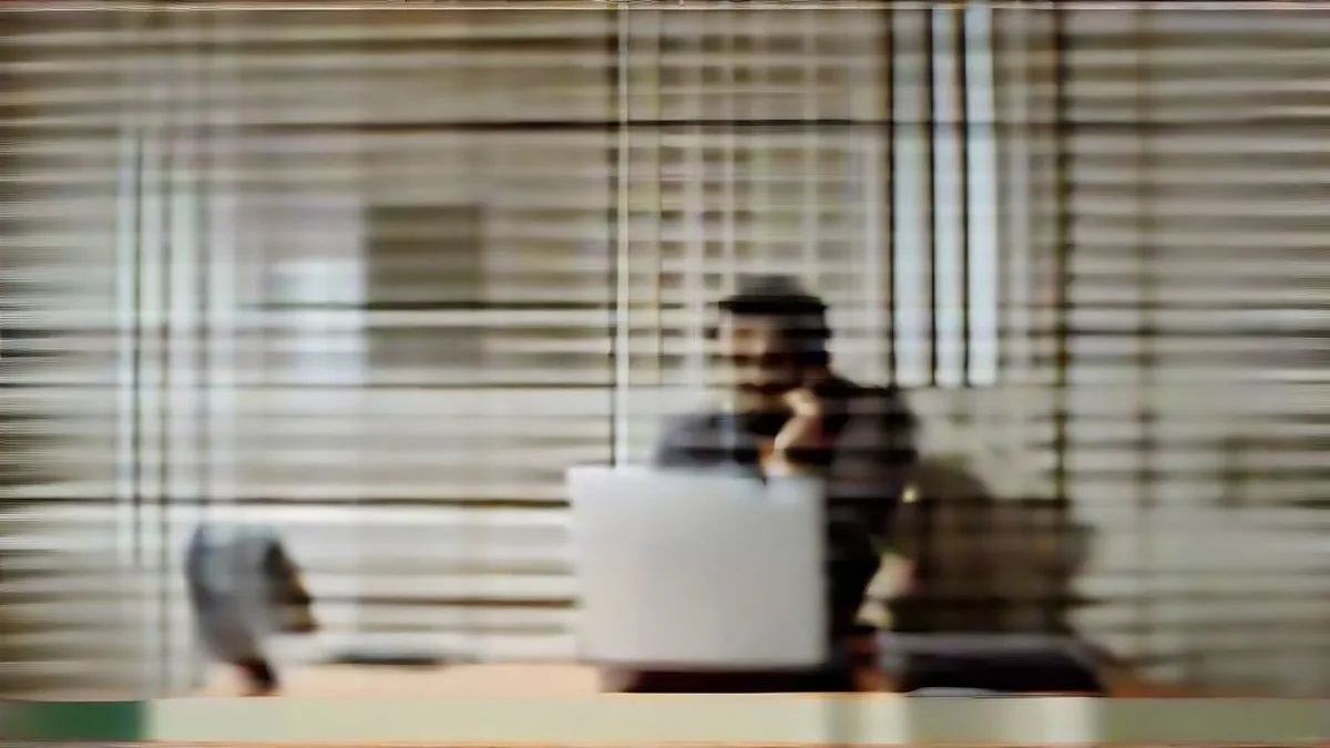 A banking professional looking anxiously at his smartphone screen in an office