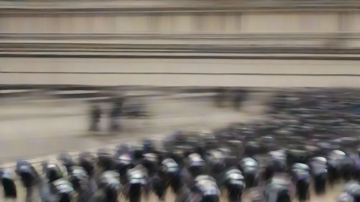Crowd of protesters gathered on a Paris street with police presence in the background.