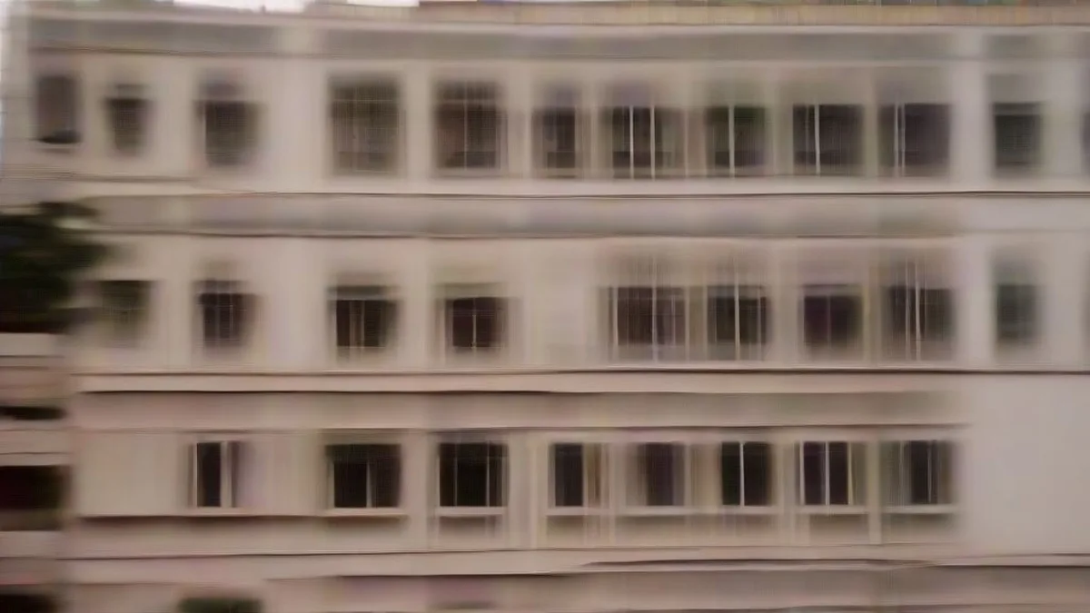 Exterior view of a student hostel building in Kota during the evening with police presence.